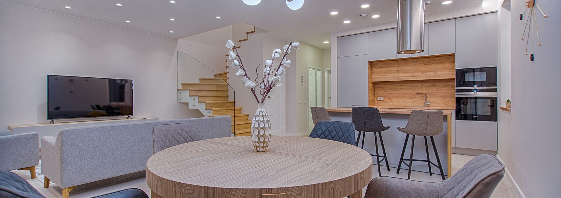 round brown wooden table with chairs inside room 1668860